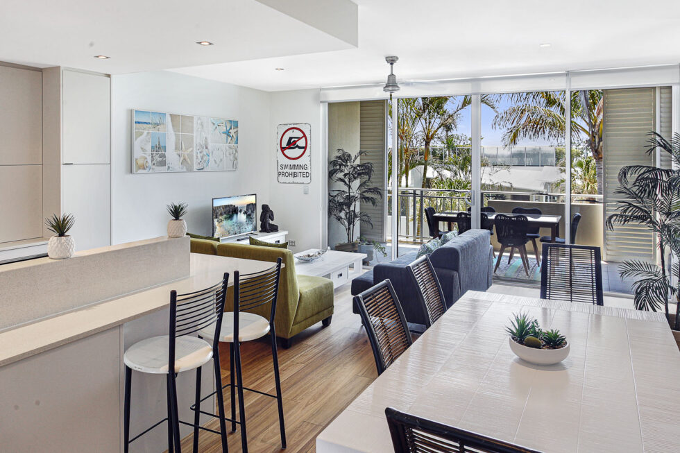 Pool View 2 Bedroom Apartment kitchen island and dining area opening to balcony
