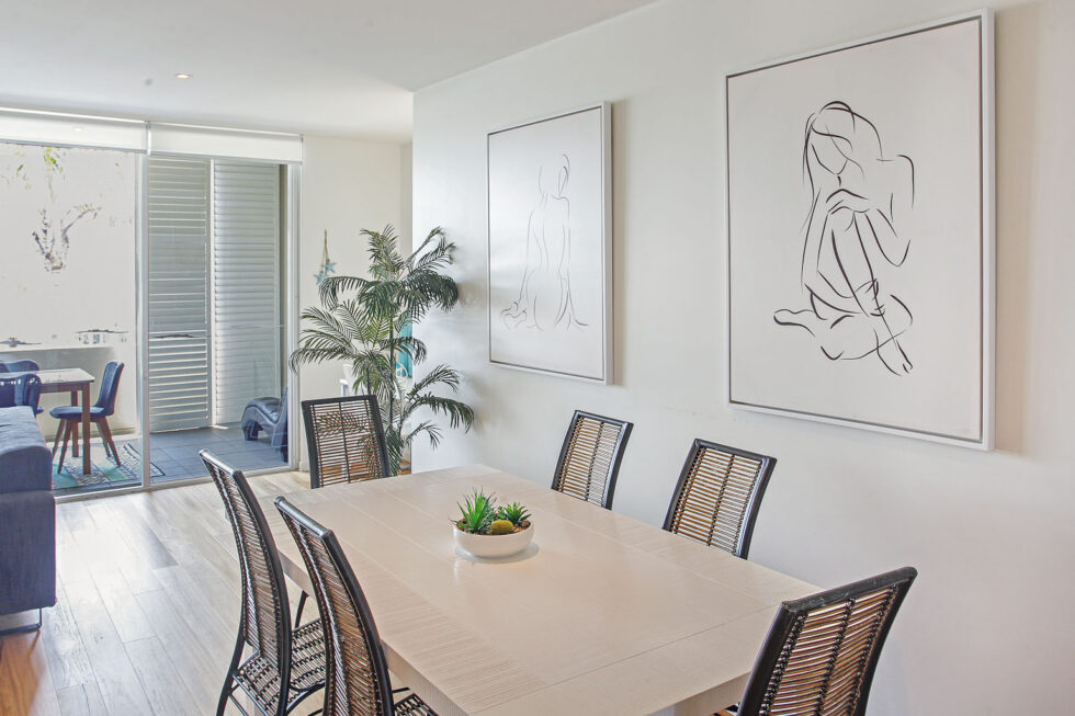 Pool View 2 Bedroom Apartment dining table with coastal artwork