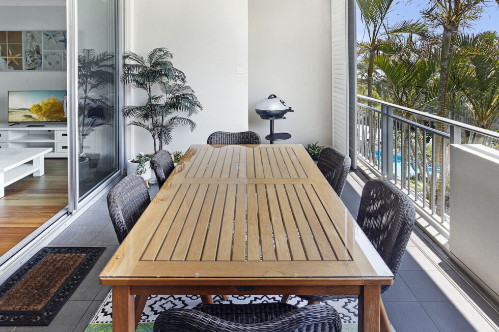 Pool View 2 Bedroom Apartment balcony dining setting with palm outlook