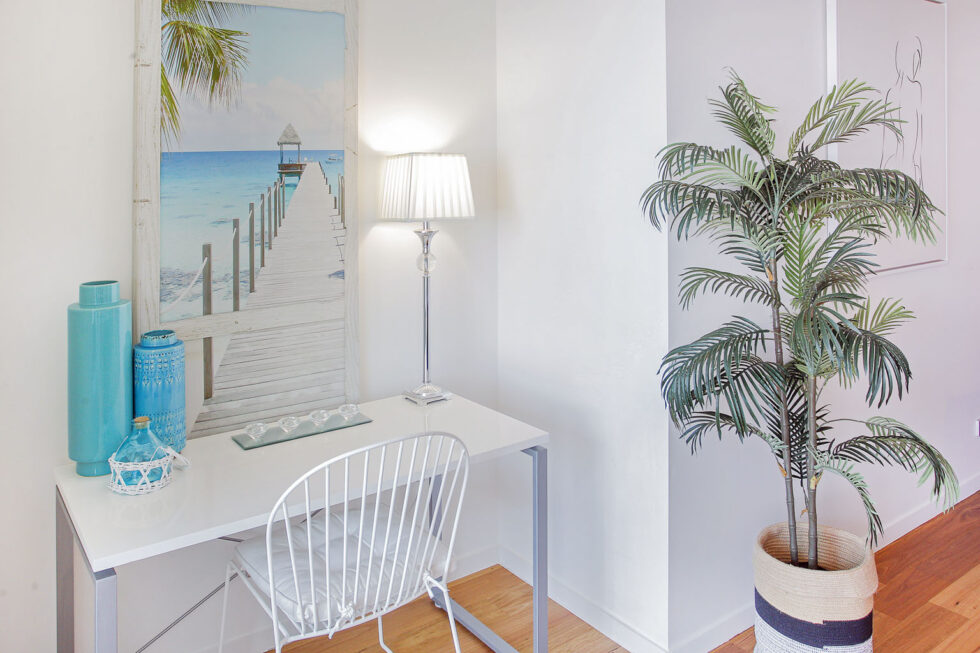 Pool View 2 Bedroom Apartment entry console with beach artwork and plant
